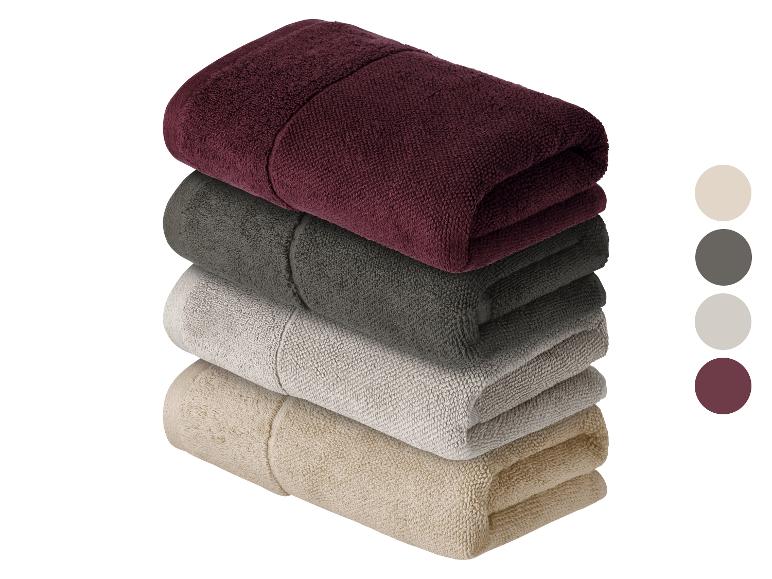 Stapel handdoeken in verschillende kleuren.