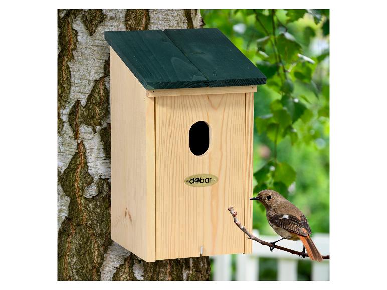 Licht houten vogelhuisje met donkergroen dak, bevestigd aan een boom, met een vogel op een tak.