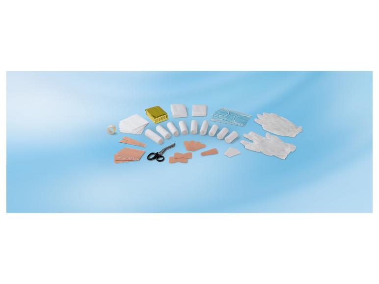EHBO-kit met verband, pleisters, handschoenen, maskers en schaar op blauwe achtergrond.