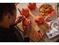 Persoon snijdt Halloweenpompoenen met snijgereedschap en zaden.