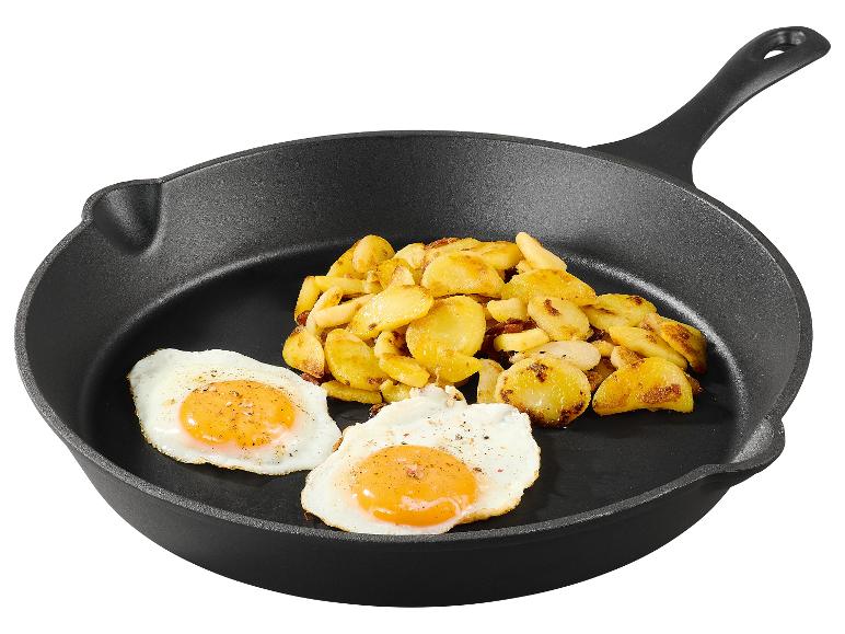 Eieren en gebakken aardappelen in een gietijzeren pan.