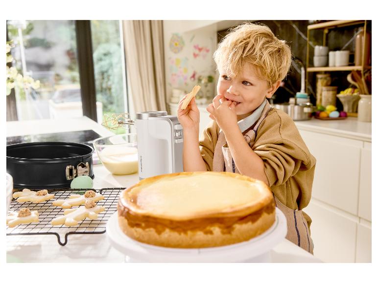 Jongen eet koekje naast Silvercrest mixer en cheesecake in de keuken