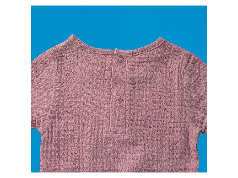 Roze kinder top met korte mouwen en knoopjes op de rug.