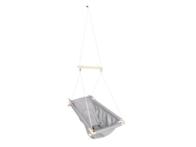 Hangende babyschommel van grijze stof met houten stangen en witte touwen