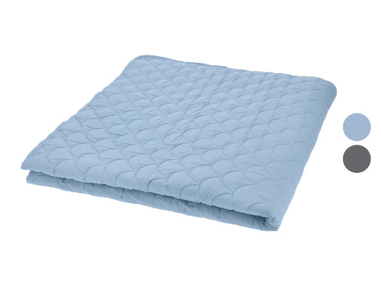 Blauwe gewatteerde sprei of deken met twee kleurstalen.
