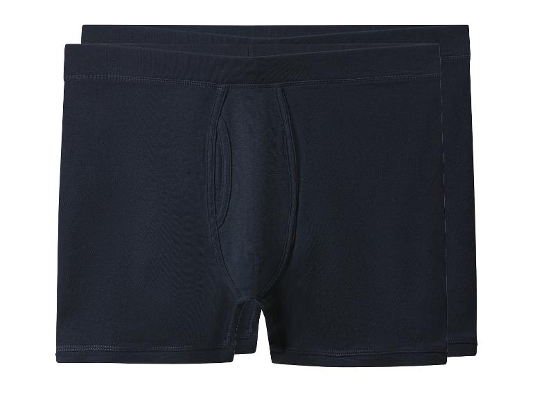 Twee paar donkerblauwe herenboxershorts gevouwen en gestapeld.