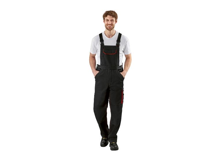 Lachende man in zwarte overall en wit T-shirt