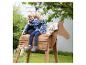Twee lachende kinderen zitten buiten op een houten speelgoedpaard.