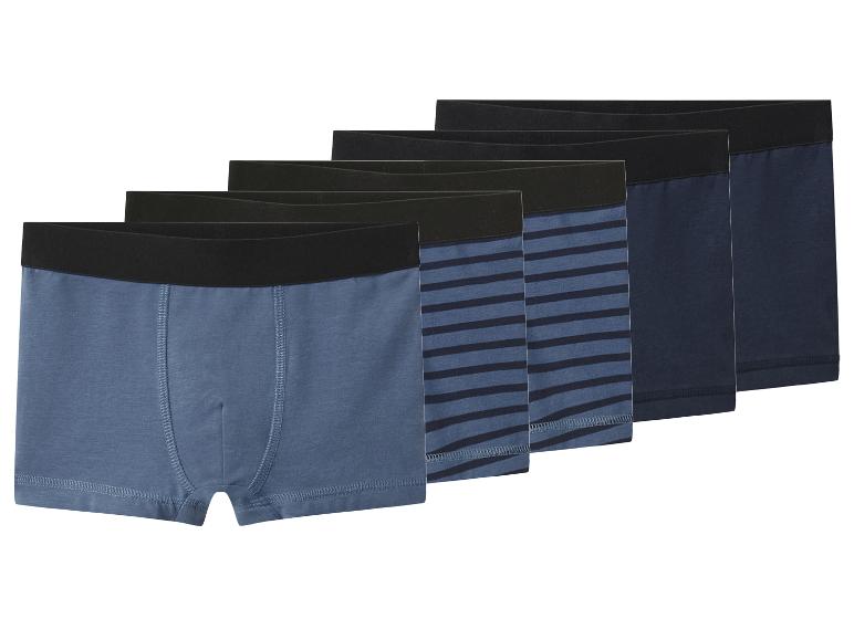 Vijf herenboxershorts in blauwtinten, sommige effen, sommige gestreept.