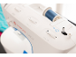 Witte naaimachine met een klos blauw garen en schuifregelaars.