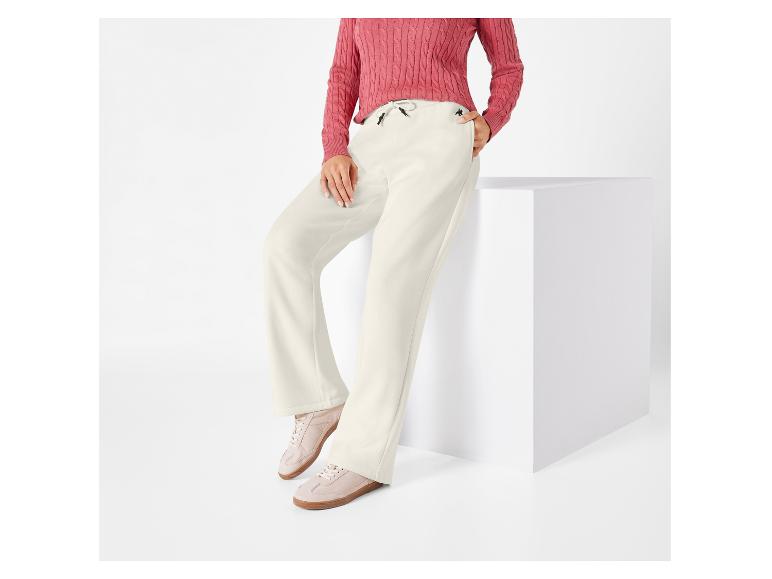 Witte broek met een K-logo en roze trui.