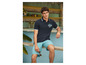 Man draagt een blauwe polo met Surf Shop logo en blauwe shorts.