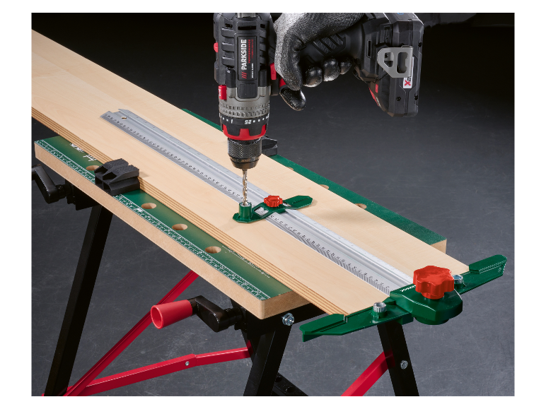Een Parkside boormachine wordt gebruikt met een timmermansgereedschap op een werkbank.