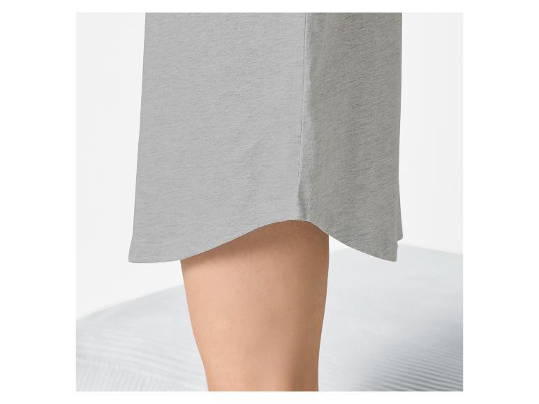 Onderkant van een grijze jurk met een asymmetrische zoom en een ontbloot been.