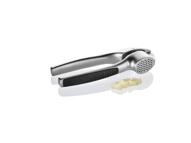 Metalenen knoflookpers met geperste knoflook.