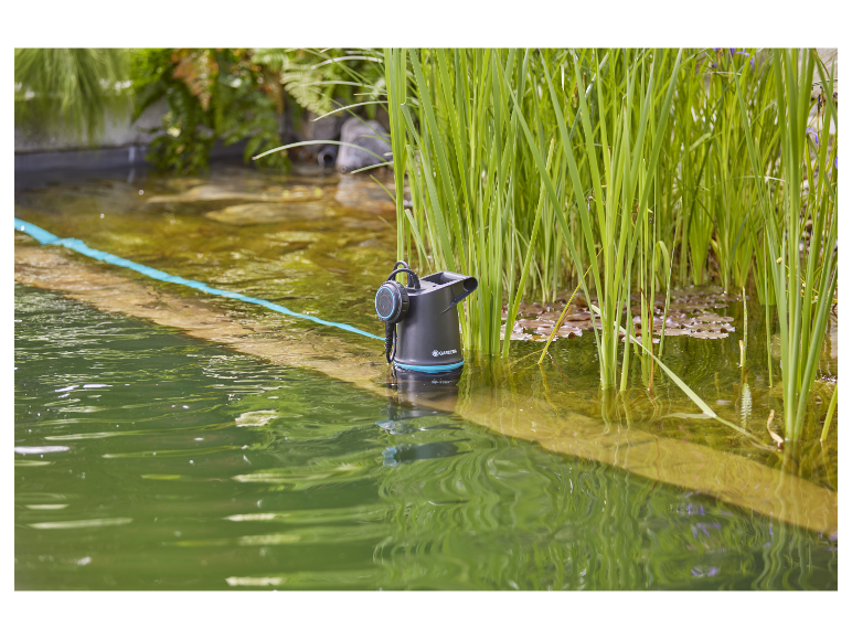 Gardena vijverpomp in het water tussen planten.