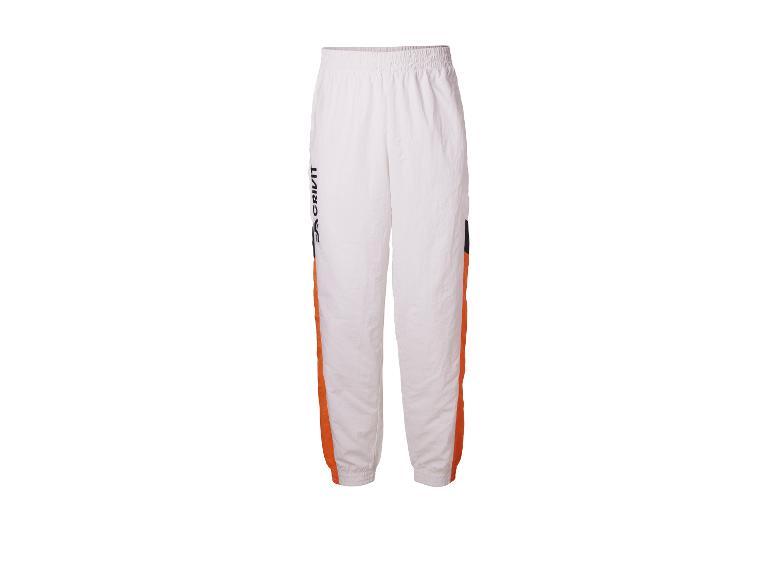 Witte trainingsbroek met oranje en zwarte details.