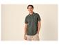 Jonge man in donkergroen poloshirt met streepdetails en beige shorts.