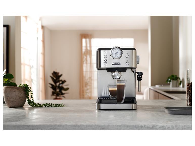 De'Longhi espressomachine met manometer en twee koffiekopjes in een lichte keuken.