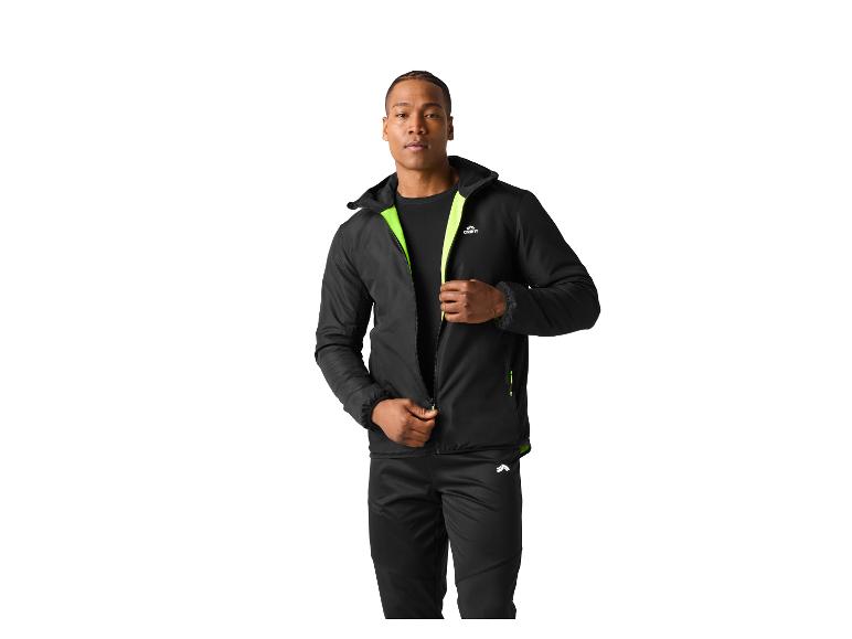 Man in zwart sportjack en broek met limoengroene details