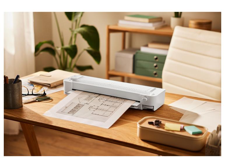 Architectenplannen en snijmachine op een bureau.