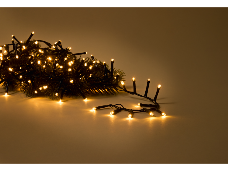 Kerstverlichting met warme LED-lampjes op een effen achtergrond.