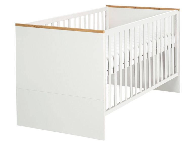 Wit babybedje met houten accenten.