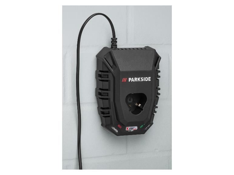 Zwarte acculader voor elektrisch gereedschap met kabel, gemonteerd aan een witte bakstenen muur.