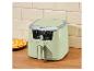 Lichtgroene airfryer met digitaal display (175 graden) op een houten aanrecht naast een bord friet.