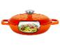 Oranje gietijzeren braadpan met doorsnede die courgettenoedels en tomaten toont.