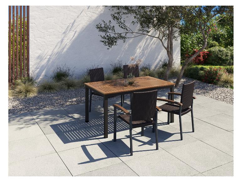 Buiten eethoek met houten tafel en rieten stoelen op terras
