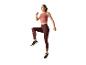 Vrouw in sportkleding springt.