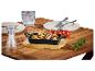 Zwarte gietijzeren pan met biefstuk, champignons en rozemarijn op een houten tafel.