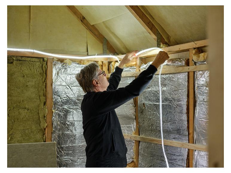 Man installeert LIVARNO® Leuchtschlauch »The Renovator« lichtslang op zolder.