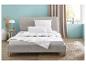 Moderne slaapkamer met grijs bed, wit Balette beddengoed, kussens en een gewatteerd dekbed.