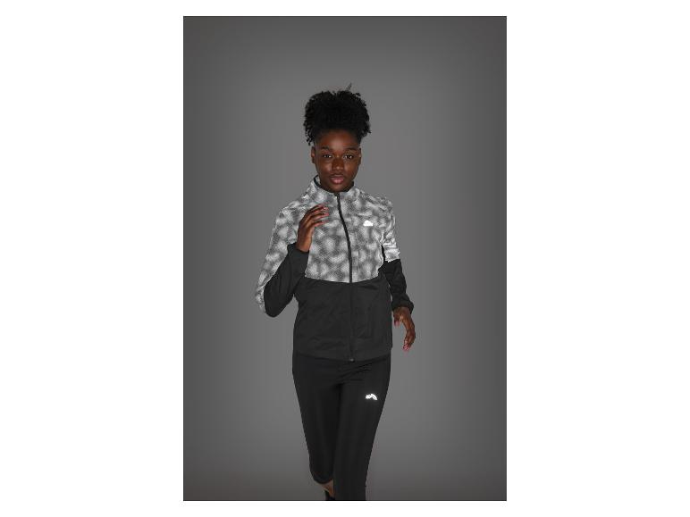 Vrouw in reflecterende zwart-grijze sportkleding, klaar om te rennen.