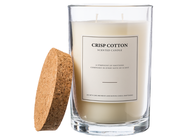 Een geurkaars in een glazen pot met kurken deksel, gelabeld 'Crisp Cotton'.