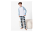 Jongetje modelleert comfortabele pyjama met blauw-wit gestreept shirt en geruite broek.