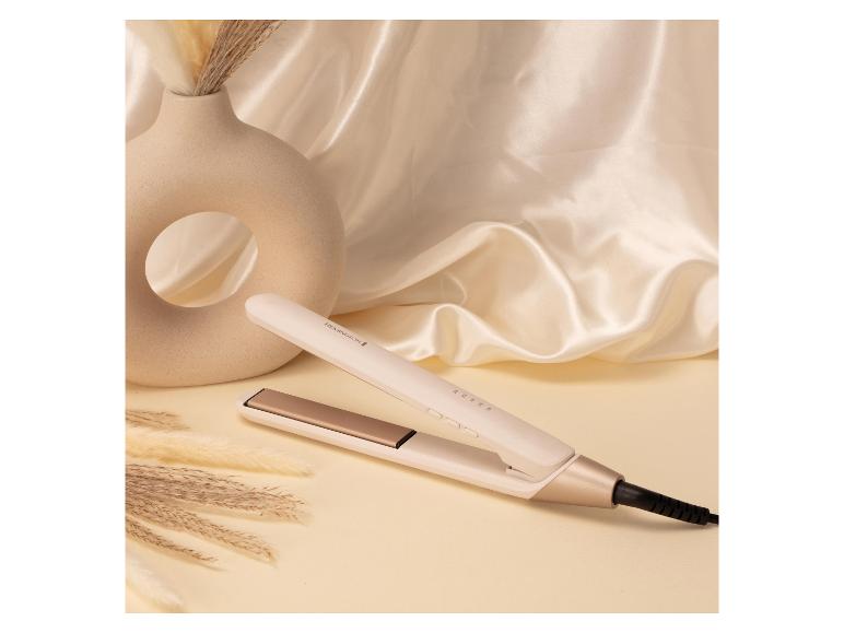 Witte en gouden stijltang, decoratieve vaas en pampasgras op een zijden achtergrond.