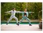 Vrouw in CRIVIT sweatpants en man die yoga doen bij het zwembad