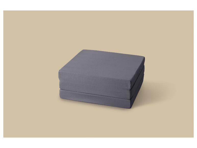 Grijs opvouwbaar matras op een beige achtergrond