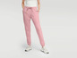 Vrouw draagt roze joggingbroek met witte sneakers.