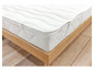 Een wit matras met golvende structuur op een houten bedframe.