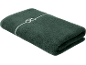 Opgevouwen donkergroene handdoek met een wit decoratief patroon.