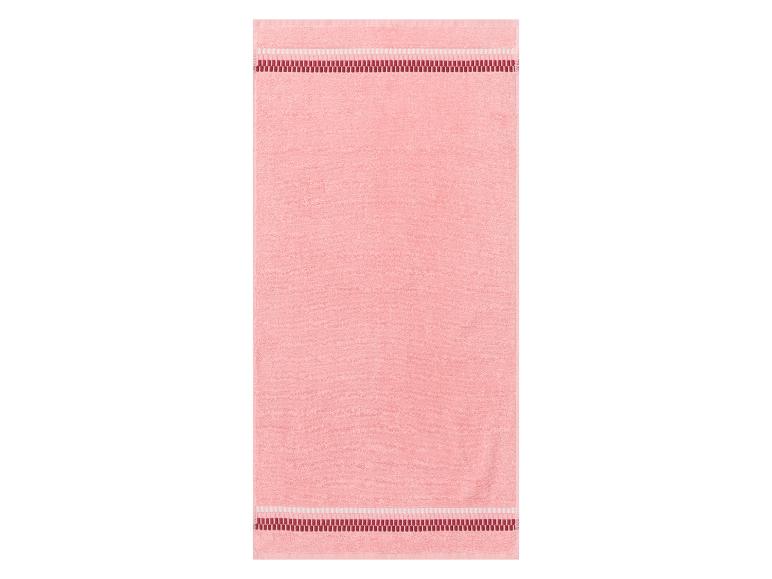 Een roze badhanddoek met rode rand.