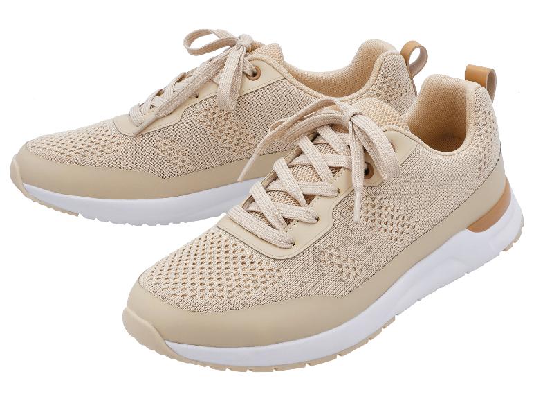Twee beige sneakers met veters, witte zolen en lichtbruine details.