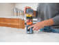 Persoon bereidt smoothie in draagbare blender met fruit en groenten.