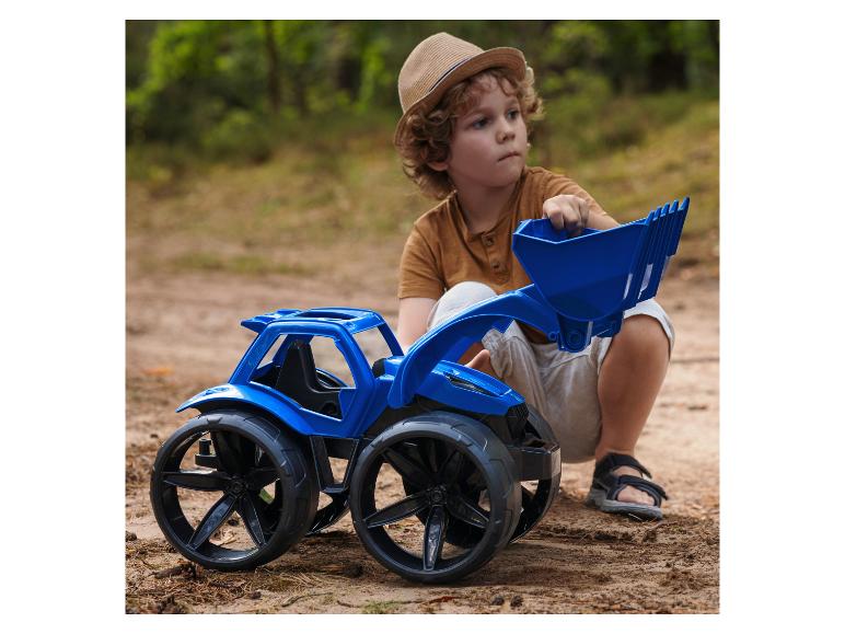 Jongen speelt met een blauwe speelgoedtractor in een bosrijke omgeving.