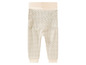 Beige broek met zwarte stippen.