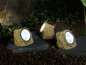 Drie solar tuinlichten in de vorm van stenen.
